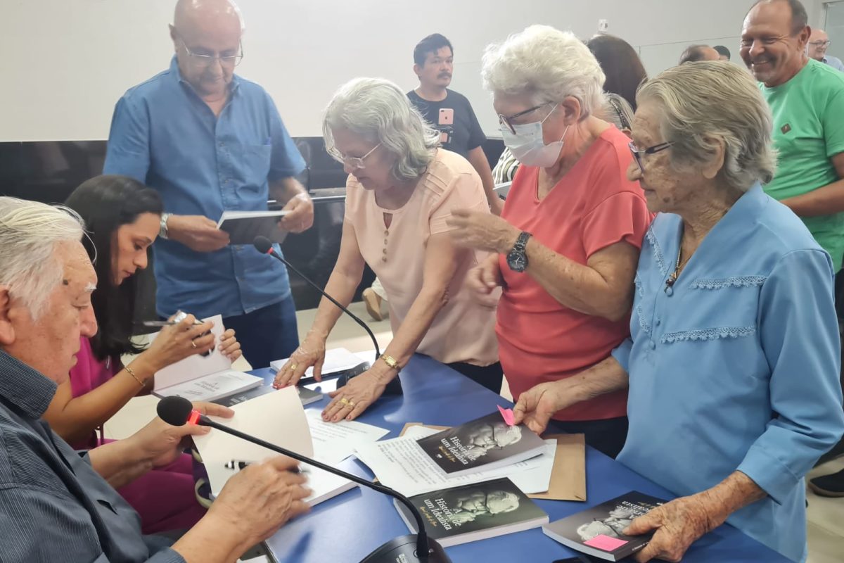 Manoel Carvalho autografa seu livro.